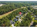 An aerial view showing the home's location near a golf course and surrounded by lush trees at 168 Mackinley Circle, Pawleys Island, SC 29585