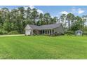 Single-story home featuring an attached garage, manicured lawn, established landscaping and fenced-in backyard at 173 Crossroad Dr. Nw, Calabash, NC 28467