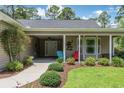 Inviting front porch with cozy seating and meticulous landscaping offers curb appeal at 173 Crossroad Dr. Nw, Calabash, NC 28467