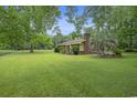 Brick house with a well-manicured lawn and mature trees at 1731 Lee Ln., Longs, SC 29568