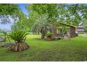 Lush green lawn with palm trees and a charming brick house at 1731 Lee Ln., Longs, SC 29568