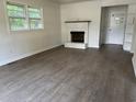 Cozy living room featuring a painted brick fireplace and durable, modern flooring at 205 S Oliver Blvd., Hemingway, SC 29554