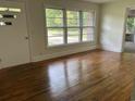 Sunlit living room with gleaming hardwood floors and large windows offering picturesque views at 205 S Oliver Blvd., Hemingway, SC 29554