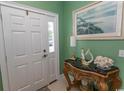 Inviting entryway with decorative table, white paneled front door, and attractive art at 2428 Little River Neck Rd. # 101, North Myrtle Beach, SC 29582