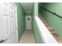 Hallway and stairway featuring tiled floors, painted walls, and stylish wooden steps at 2428 Little River Neck Rd. # 101, North Myrtle Beach, SC 29582