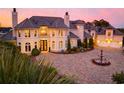 A luxurious home is beautifully landscaped and lit, highlighting a circular driveway with fountain at 2715 Ships Wheel Dr., North Myrtle Beach, SC 29582