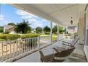 Relaxing front porch features rocking chairs, hanging ferns, and a view of the landscaped yard at 29 Saltwind Loop, Murrells Inlet, SC 29576