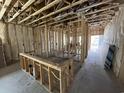 Open-concept room featuring stud framing, visible insulation, and natural light from the door at the end of the room at 3038 Palma Way, Myrtle Beach, SC 29579