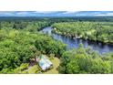 Stunning aerial view of a secluded riverfront home surrounded by lush green forest and blue skies at 3231 Center Rd., Georgetown, SC 29440