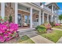 Inviting front porch with white columns and flowering shrubs leading to the main entrance at 3477 Bristol Ln. # 3477, Myrtle Beach, SC 29577