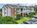 Charming condo exterior with brick accents, private balconies, and lush landscaping at 3795 Hitchcock Way # 613, Myrtle Beach, SC 29577