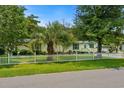 Attractive single-story home with green shutters, a green roof, a palm tree and a white picket fence at 3839 Woodridge Circle, Little River, SC 29566