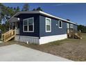 Single-story home featuring navy blue siding, white trim, and wood stairs leading to both entrances at 401 Cessna St, Myrtle Beach, SC 29577