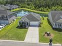 Aerial view of home with pond, fountain, lush green lawn, and manicured landscaping at 519 Royal Jay Ln., Longs, SC 29568