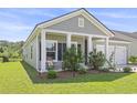 Inviting front porch with rocking chair seating and mature landscaping at 519 Royal Jay Ln., Longs, SC 29568