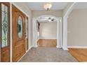 Inviting foyer with decorative columns, tile flooring, arched doorway, and a wooden front door at 6161 Inman Circle, Conway, SC 29526