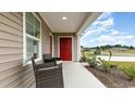 Inviting front porch with seating, complemented by a red door and well-maintained landscaping at 651 Culmen Ct., Myrtle Beach, SC 29588