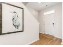 Inviting foyer featuring hardwood floors, a front door with transom window, and an elegant heron print at 739 Chazen Way, Longs, SC 29568