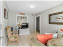 Living room features tiled floors, neutral colored walls, comfortable chair, and a window at 824 N Waccamaw Dr. # 203, Murrells Inlet, SC 29576