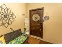 Condo entrance with decorative wreath, bench, and welcome sign creating a cozy, inviting atmosphere at 108 Pipers Ln. # 108, Myrtle Beach, SC 29575