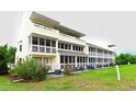 Condominium back exterior view showing screened in porches and well manicured landscape at 1100 Possum Trot Dr. # D106, North Myrtle Beach, SC 29582