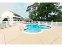 Community pool surrounded by white picket fence, lounge chairs, and covered picnic area at 1100 Possum Trot Dr. # D106, North Myrtle Beach, SC 29582