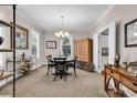 Bright dining room featuring chandelier lighting, wooden furniture, and a window at 110-1 Whitetail Way # 1, Pawleys Island, SC 29585