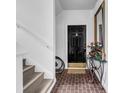 A welcoming entryway featuring brick floors, a black door, a mirror, and stair access at 110-1 Whitetail Way # 1, Pawleys Island, SC 29585