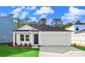 New construction home with white siding, black door, attached garage, and manicured lawn under sunny skies at 1217 Willow Oaks Way, Conway, SC 29526