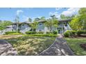Two-story condo building with gray siding, walkways and well-maintained landscaping under a partially cloudy sky at 1221 Tidewater Dr. # 122, North Myrtle Beach, SC 29582