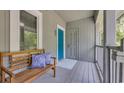 Inviting porch with a wooden bench, decorative pillows, and a charming blue front door at 1221 Tidewater Dr. # 122, North Myrtle Beach, SC 29582