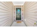 Close-up of the front door with a decorative wreath, and a neutral colored mat at 142 Pine Forest Dr., Conway, SC 29526