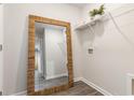 Functional laundry area with a large mirror, storage shelving and modern gray vinyl flooring at 1710 Whispering Pine St., Ocean Isle Beach, NC 28469