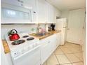 Compact kitchen features white cabinets, a stove, microwave, and refrigerator at 1805 Windmere W S Ocean Blvd. # 1109, Myrtle Beach, SC 29575