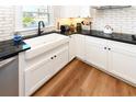 Well-lit kitchen with a white farmhouse sink, modern faucet, and white cabinets at 1931 Lakeview Circle, Surfside Beach, SC 29575
