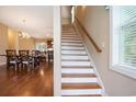 Staircase with wooden handrail and hardwood flooring visible into the kitchen and dining area at 210 Natures View Circle, Pawleys Island, SC 29585