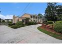 Large brick home with an expansive driveway, lush greenery, and classic architectural details and a rear pond at 328 Waterside Dr., Myrtle Beach, SC 29577