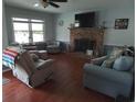 Cozy living room featuring a brick fireplace, comfortable seating, and natural light at 4083 Sand Trap Ave., Little River, SC 29566