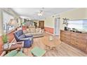 Well-lit living room with cozy seating, hardwood floors, and access to the kitchen and dining areas at 4350 Intercoastal Dr. # 1101, Little River, SC 29566