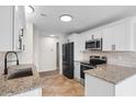 Modern kitchen featuring white cabinetry, granite countertops, stainless steel appliances, and tile flooring at 4387 Heartwood Ln., Myrtle Beach, SC 29579