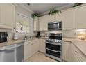 Bright kitchen features stainless steel appliances and cream-colored cabinets, perfect for cooking at 4878 Luster Leaf Circle # 102, Myrtle Beach, SC 29577