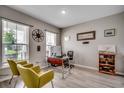 Bright home office featuring a work desk, shelving, and two comfortable yellow chairs at 5013 Sassari St., Myrtle Beach, SC 29579