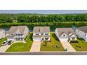Aerial view of a beautiful white home near a serene pond and lush greenery at 560 Pier Ct., Longs, SC 29568