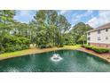 Scenic pond with a fountain, surrounded by lush landscaping and mature trees at 5825 Catalina Dr. # 523, North Myrtle Beach, SC 29582