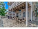 Outdoor deck area with dining table and seating, partially shaded by the home's upper balcony, perfect for relaxing at 6001- 8005 S Kings Hwy., Myrtle Beach, SC 29575