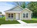 Attractive single-level home featuring green siding, contrasting white trim, and a concrete walkway at 608 Miles Ct, Marion, SC 29571
