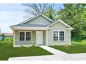 Cozy home with green siding, complemented by bright white trim and a tidy lawn and walkway at 608 Miles Ct, Marion, SC 29571