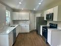 Modern kitchen featuring white cabinets, stainless steel appliances, and marble countertops at 608 Miles Ct, Marion, SC 29571
