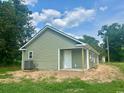 Back exterior view of a light green home with black roof and an AC unit at 608 Miles Ct, Marion, SC 29571