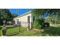 Well-maintained side yard with a black fence, lush green lawn, and mature trees offering privacy at 618 Wintercreeper Dr., Longs, SC 29568